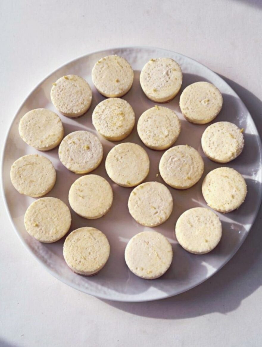 Frozen Lemon Cheesecake Bites neatly arranged on a white plate with creamy lemon filling and golden graham cracker crust.