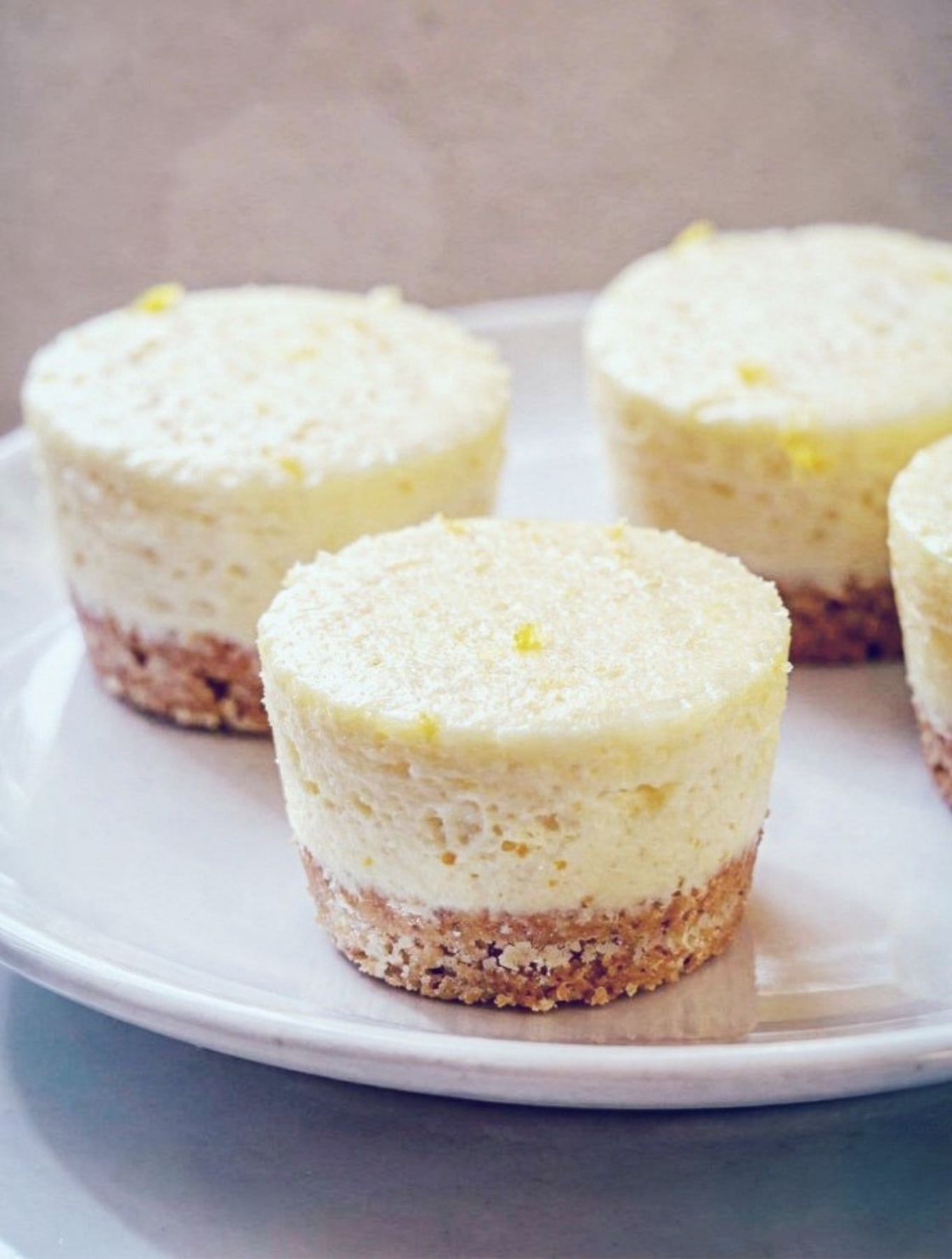 Close-up of Frozen Lemon Cheesecake Bites showing smooth lemon filling and buttery graham cracker base on a white plate.
