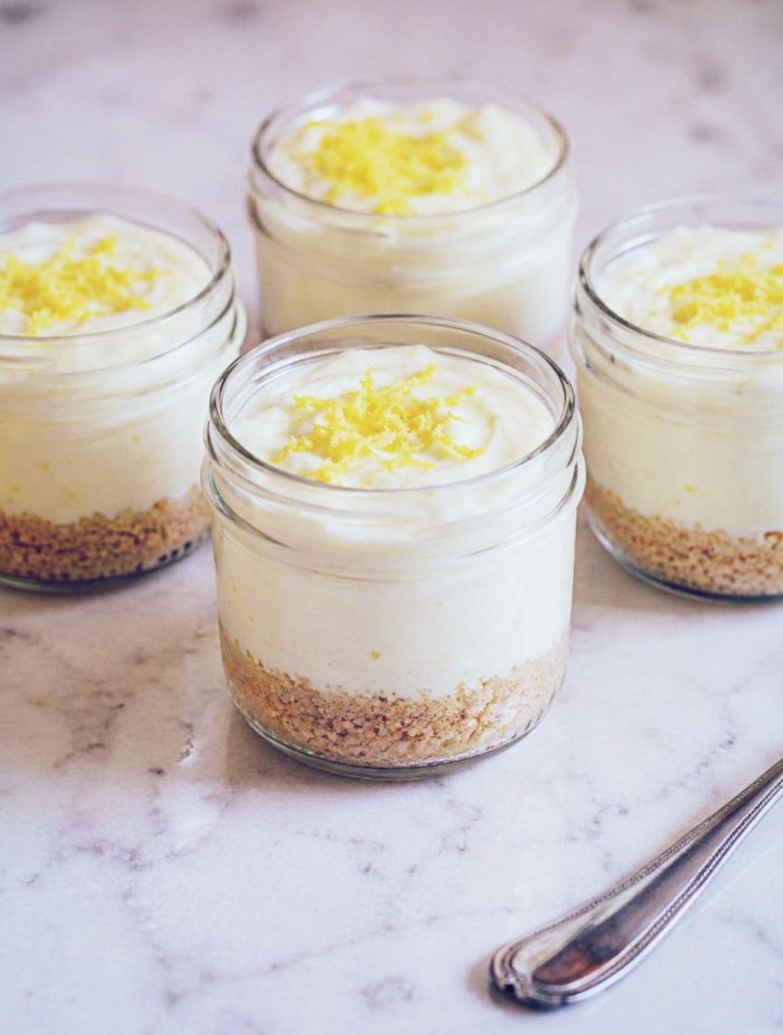 4 No-Bake Keto Lemon Cheesecake Cups topped with fresh lemon zest