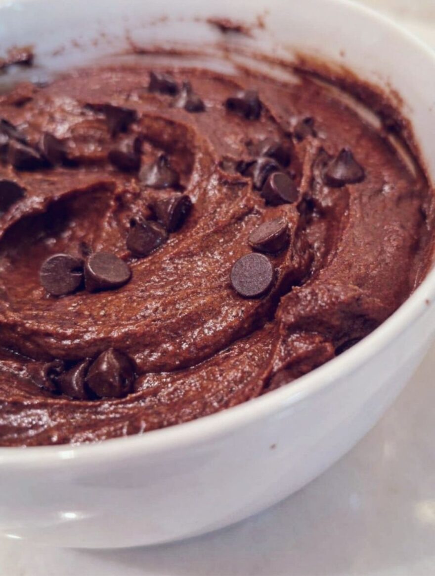 Protein Brownie Batter Dip in a white bowl topped with mini chocolate chips. A chocolate dessert rich in protein.